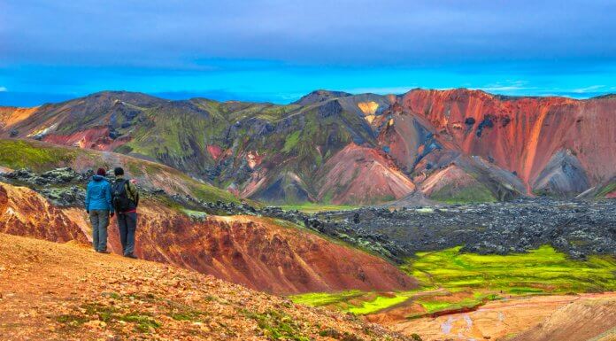 Two hikers stop to admire the beautiful rhyolite mountains in Landmannalaugar